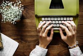 acción de manos escribiendo a máquina de escribir